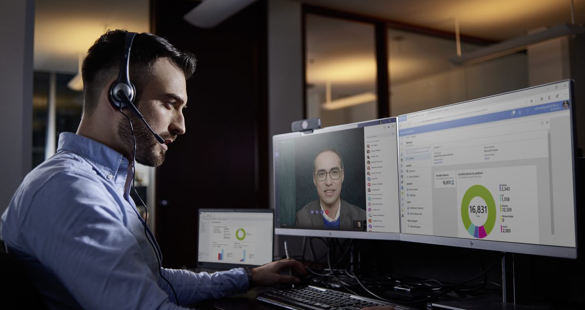 a man wearing a headset is looking into his computer