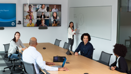 Five people in a conference room holding a video call with nine others.