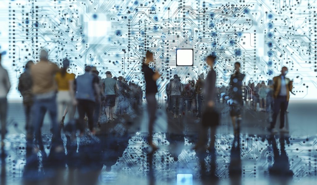 A group of people is silhouetted against a complex, illuminated circuit board pattern, creating an atmosphere of technology and innovation.